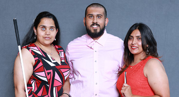Bhavini, Jaikumar, and Priya, three NFB of Oklahoma members smile together for a portrait.