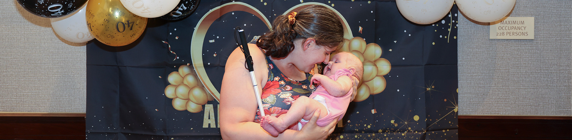 A blind mother smiles and cuddles her infant daughter.